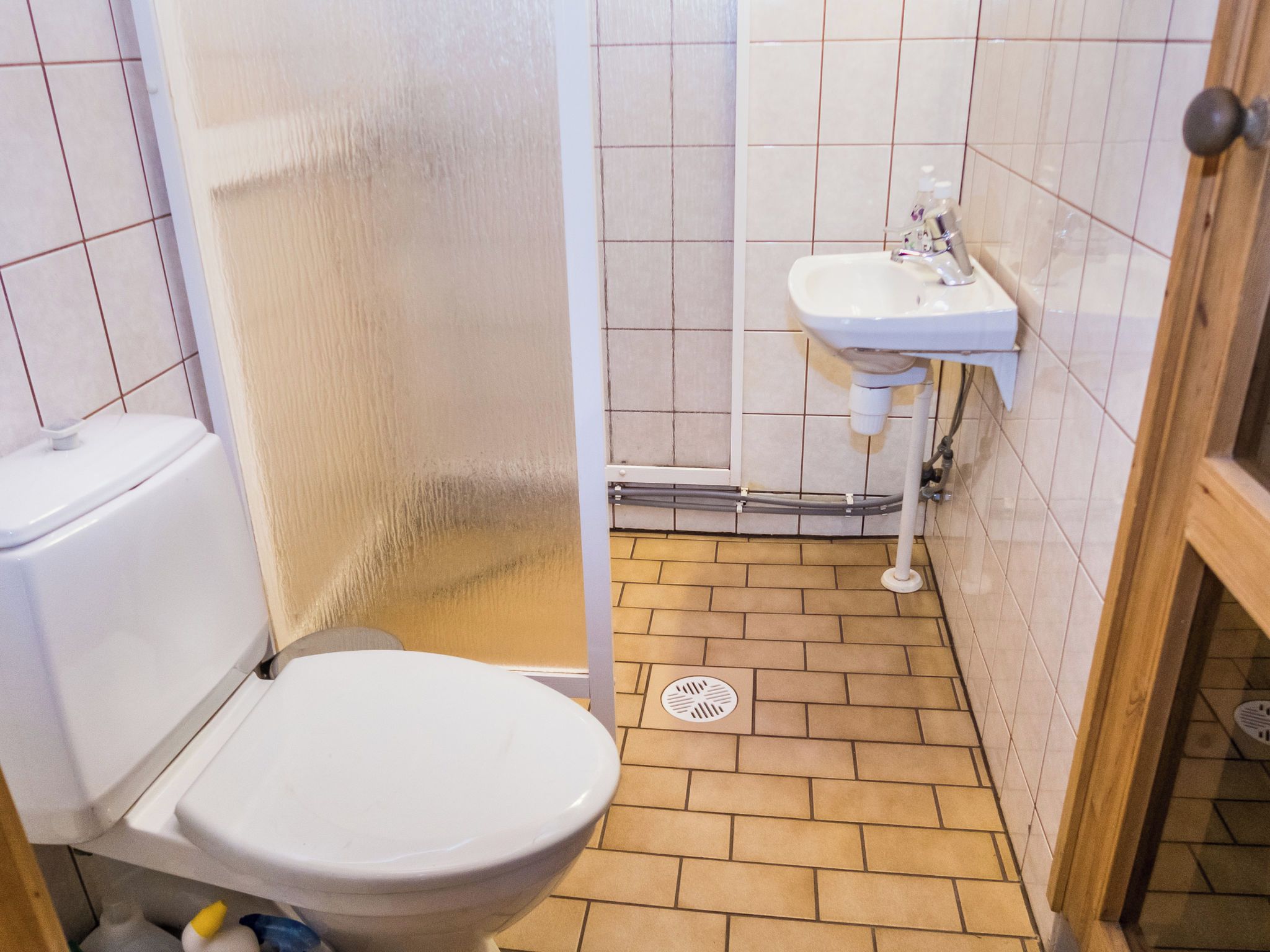 A bathroom with a toilet, a shower, and a sink.
