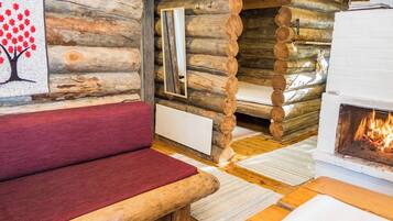 Ein Blockhaus-Interieur mit einer hölzernen Bank, einem Kamin und einem Spiegel an der Wand.