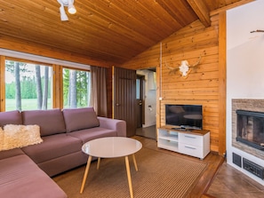 Una sala de estar acogedora con un sofá, una mesa de centro, un televisor y una chimenea.