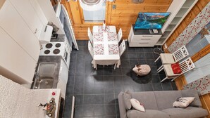 Una cocina compacta con comedor, un sofá y un televisor.