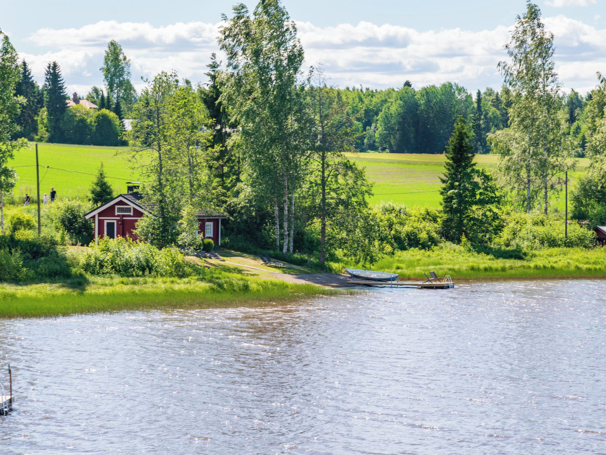 A lakeside cabin with a dock and a small boat.