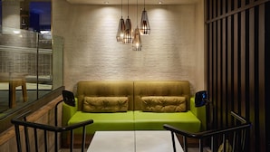Un interior moderno con un sofá verde, una mesa blanca y una lámpara colgante.