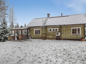 A wooden house with a metal roof, a covered porch, and a snow-covered yard. - Vacation home Josala by Interhome (Hankasalmi)