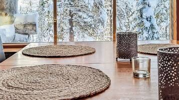 Une table à manger avec des sets de table en fibres tressées, un verre et un chandelier.