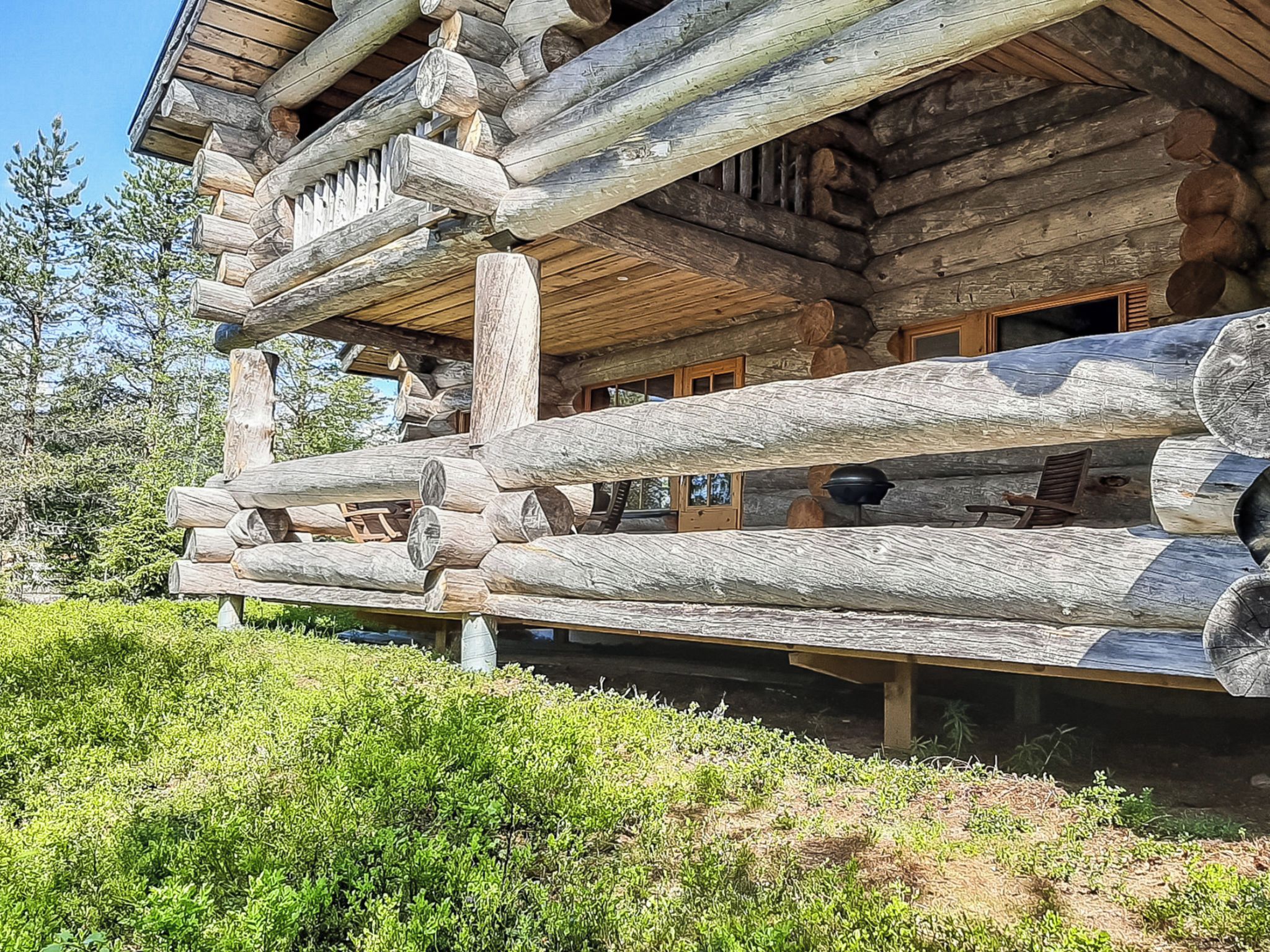 Una cabaña de madera con terraza y una mesa de comedor.