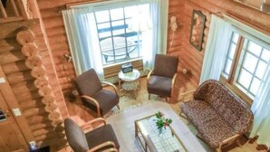 A log cabin interior with a sofa, two armchairs, a coffee table, and a window with curtains. - Vacation home 5816 by Interhome (Äänekoski)