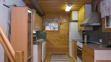 Eine kleine Küche mit Holzausstattung, einem eingebauten Backofen und einem Fenster mit Blick.