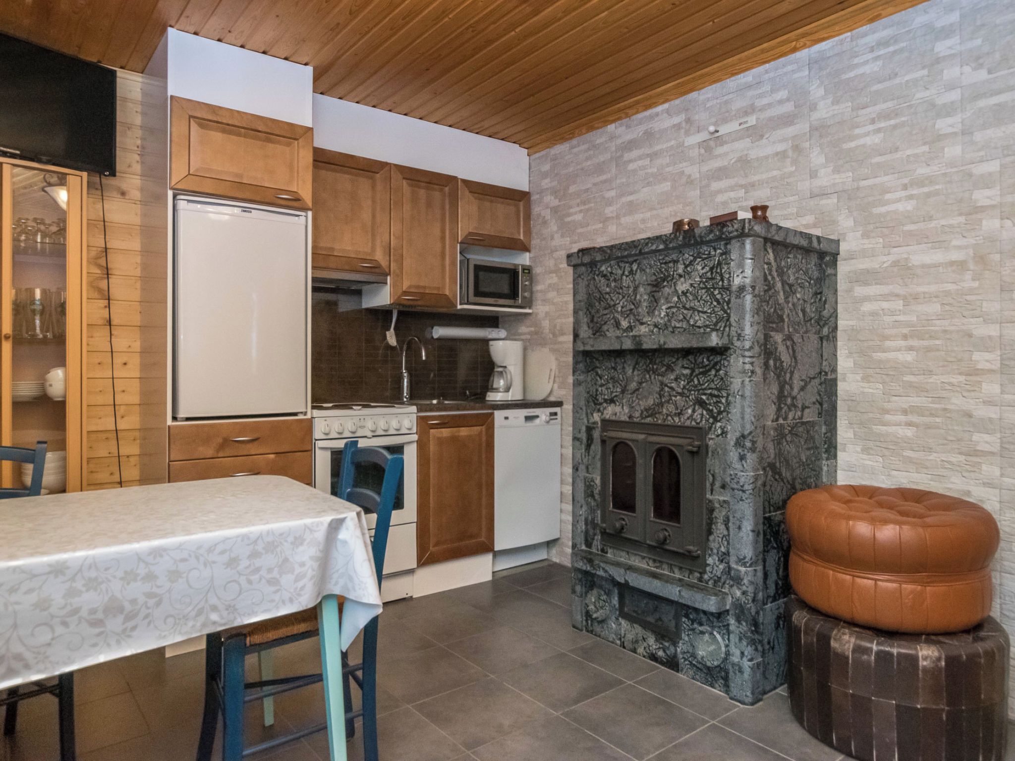 A compact kitchen with wooden cabinets, a microwave, a stove, and a built-in oven.