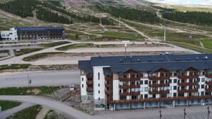 Ein mehrstöckiges Hotel mit modernem Design, mit Balkonen und einem Parkplatz.