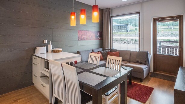 Ein moderner Wohnbereich mit Essplatz, Sofa und großen Fenstern.