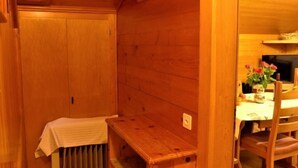 A wooden interior with a radiator, a bench, and a table with a vase of flowers. - Lärchenheim by Interhome (St Niklaus)