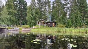 A cabin by a lake with a wooden deck and a small dock. - Suviranta by Interhome (Lapinlahti)