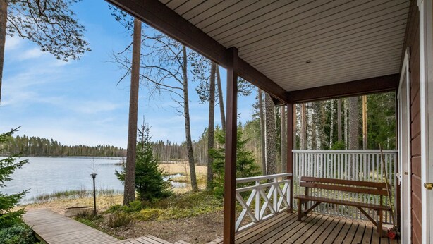 A wooden deck with a bench, overlooking a lake and forest. - Metsäpirtti by Interhome (Parkano)