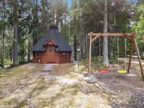 A cabin with a thatched roof, surrounded by a forest. - Metsäpirtti by Interhome (Parkano)