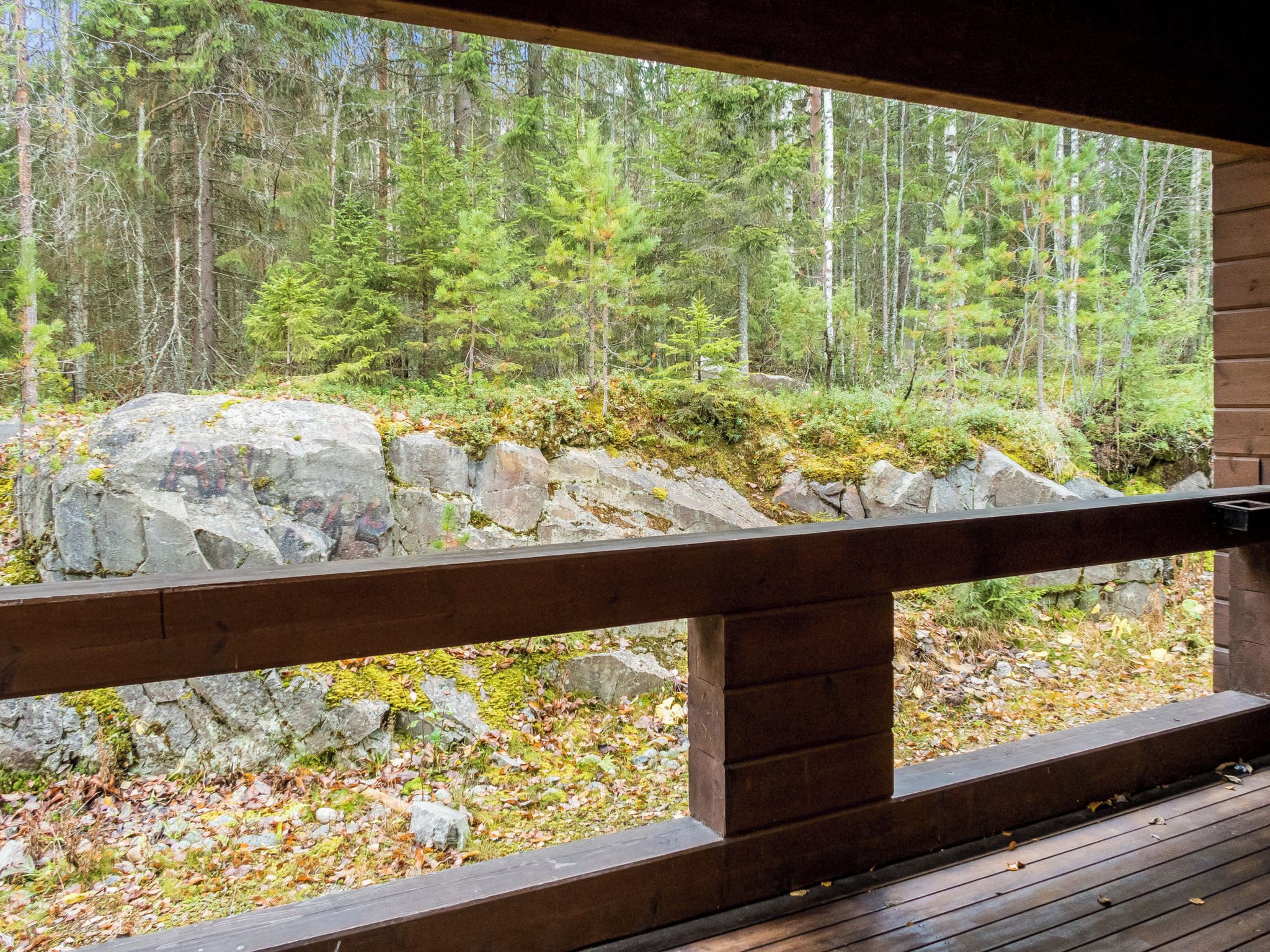 En træterrasse med udsigt over et skovområde.