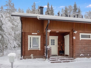 A wooden cabin with a snow-covered roof, a door labeled "Jade," and a window with a sign reading "TEAT TUNUKIE."
