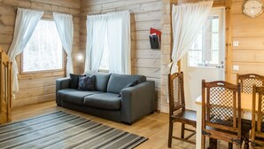 A cozy cabin interior with a sofa, chairs, a dining table, and curtains. - Klz 11. jade by Interhome (Sotkamo)