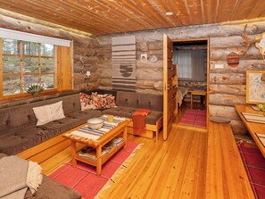 L’intérieur d’un chalet confortable, avec un canapé, une petite table et un banc.