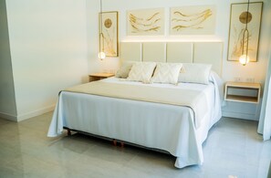 A hotel room with a large bed, bedside tables, and wall-mounted artwork. - Palmas de la Laguna by Posada Suiza (San Miguel del Monte)
