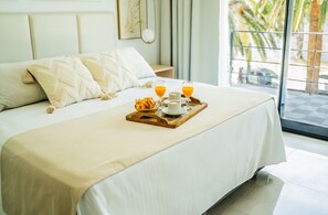 A neatly made bed with a tray of breakfast items including croissants, coffee, and orange juice. - Palmas de la Laguna by Posada Suiza (San Miguel del Monte)