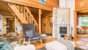 Un vaste espace de vie agrémenté d’une cheminée, d’un escalier en bois et d’un coin salon confortable.