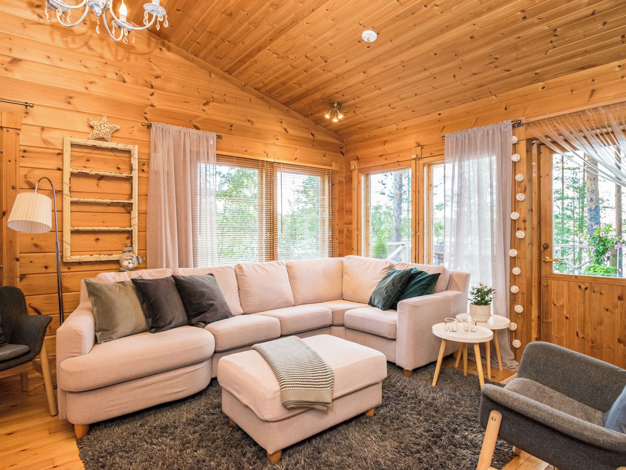Ein gemütliches Holzinterieur mit einer Eckcouch, einem kleinen runden Tisch und einem Sessel.