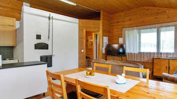 L’intérieur d’une cabane en bois comprend une cuisine, un coin repas et un espace de vie.