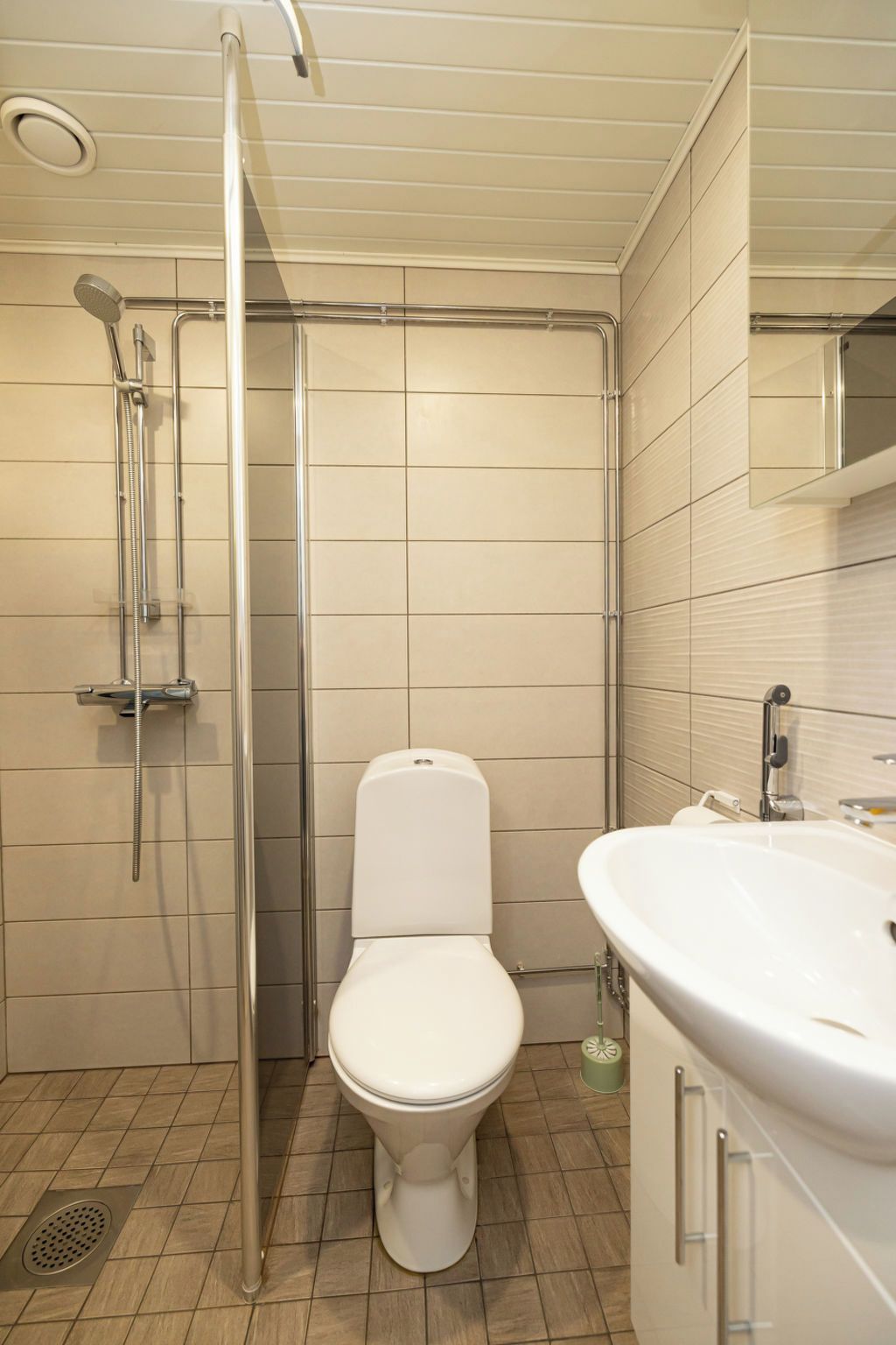 A bathroom with a toilet, a shower enclosure, and a sink.
