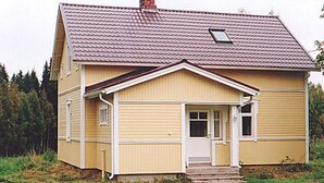 Une maison de plain-pied avec un toit à pignon, un porche à l’avant et un garage.