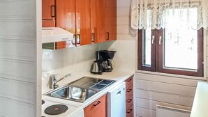 A compact kitchen with a stove, sink, and coffee maker. - Kuusela by Interhome (Kaavi)