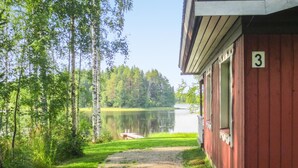 A cabin with a gravel path leading to a dock by a lake, surrounded by trees. - Kuusela by Interhome (Kaavi)