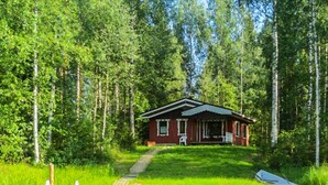 A cabin with a porch, surrounded by a forest and a body of water. - Kuusela by Interhome (Kaavi)