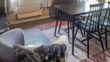 Ein Essbereich mit Tisch und Stühlen, einer Couch und einem gemusterten Teppich.