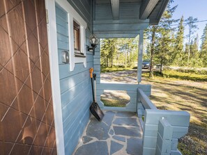 A porch with a stone floor, a shovel, and a rake leaning against the wall. - Uolevintie 39a by Interhome (Kuusamo)