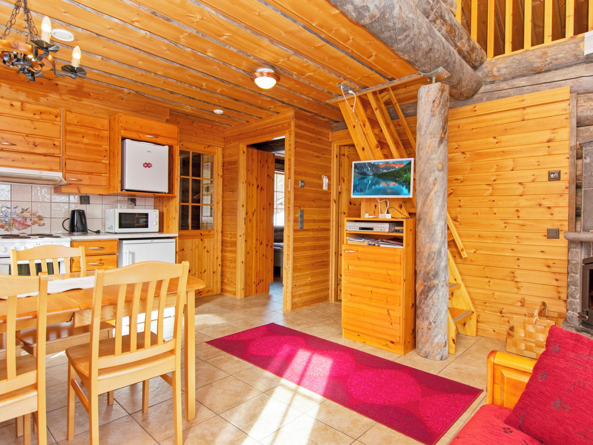 Un interior de madera con cocina, comedor y chimenea.