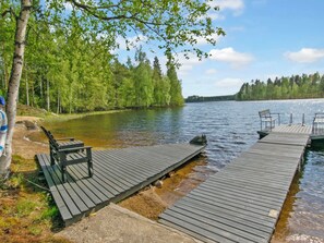 A wooden dock extending into a calm lake, surrounded by dense green trees. - Vacation home 7152 by Interhome (Sulkava)