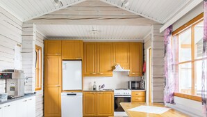 A compact kitchen with wooden cabinets, a white refrigerator, a stove, and a microwave.