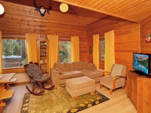 A cozy log cabin interior with a sofa, chairs, a television, and a dining area. - Vacation home Kivelä by Interhome (Kuusamo)