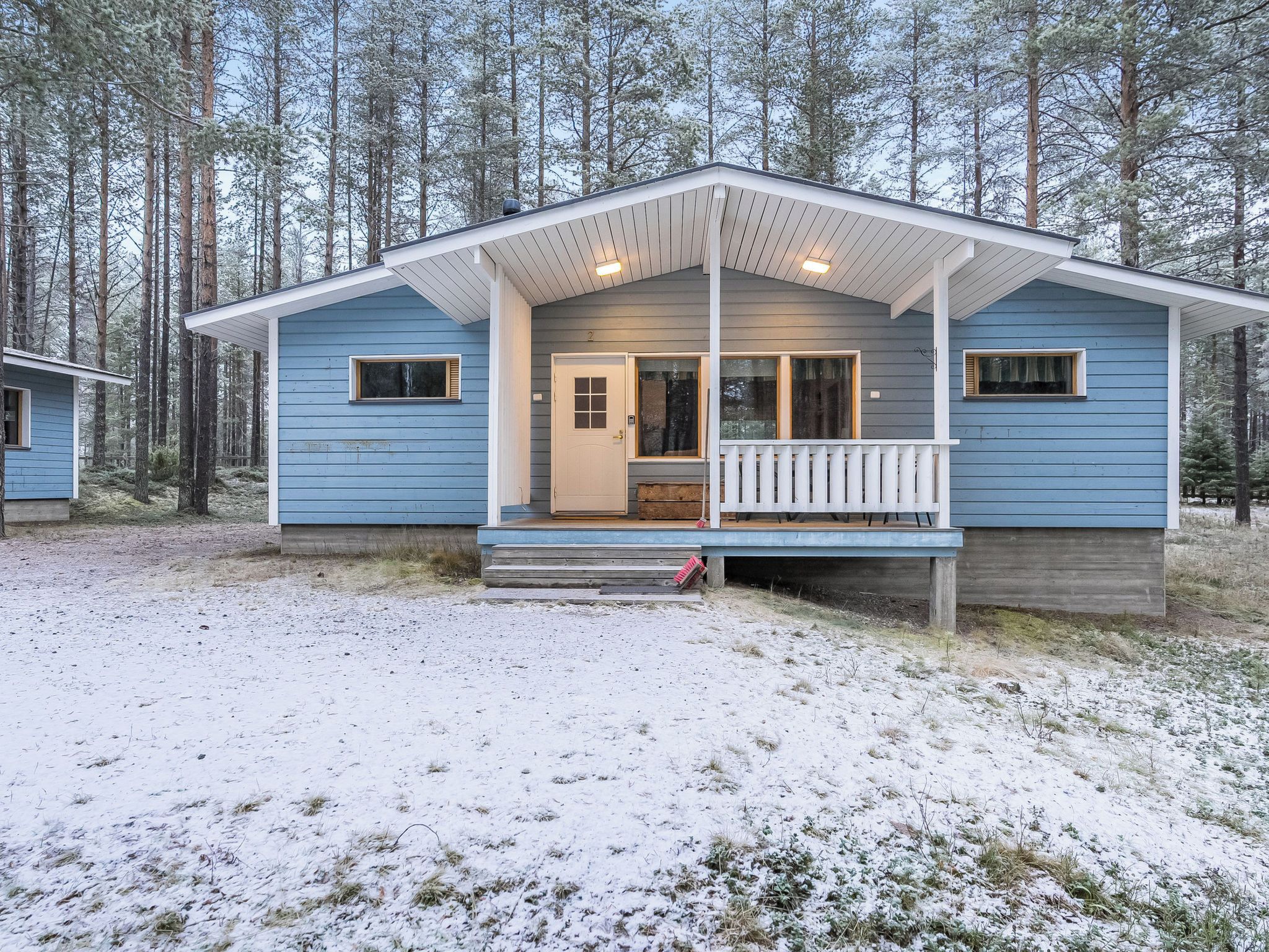 Une cabane à deux étages, dotée d’une véranda, d’une porte et d’une fenêtre.