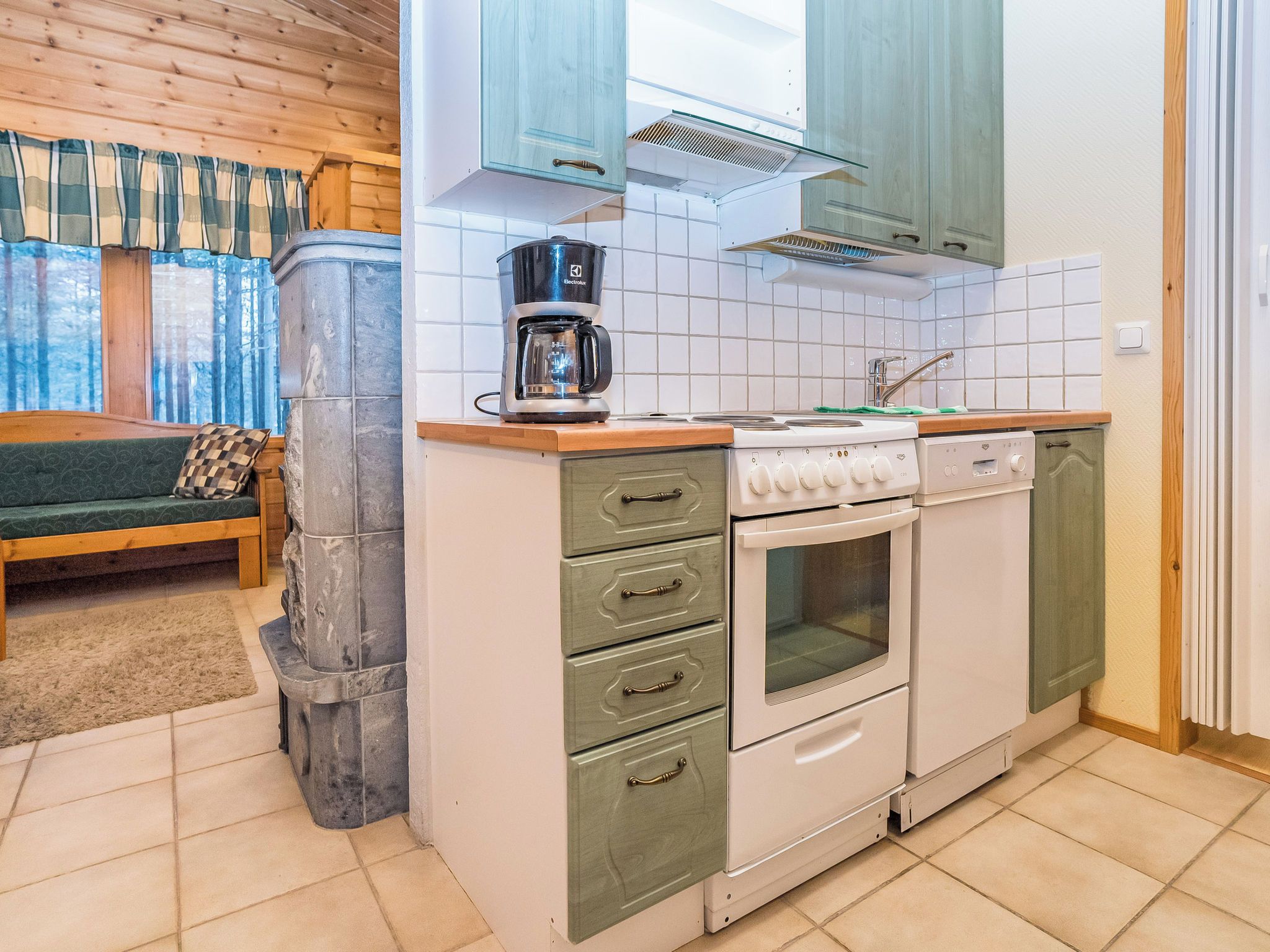 A compact kitchen with a built-in stove, oven, and a coffee maker on the countertop.