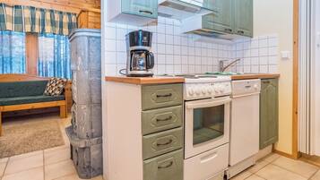 A compact kitchen with a built-in stove, oven, and a coffee maker on the countertop.