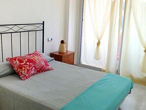 2 dormitorios y tabla de planchar con plancha