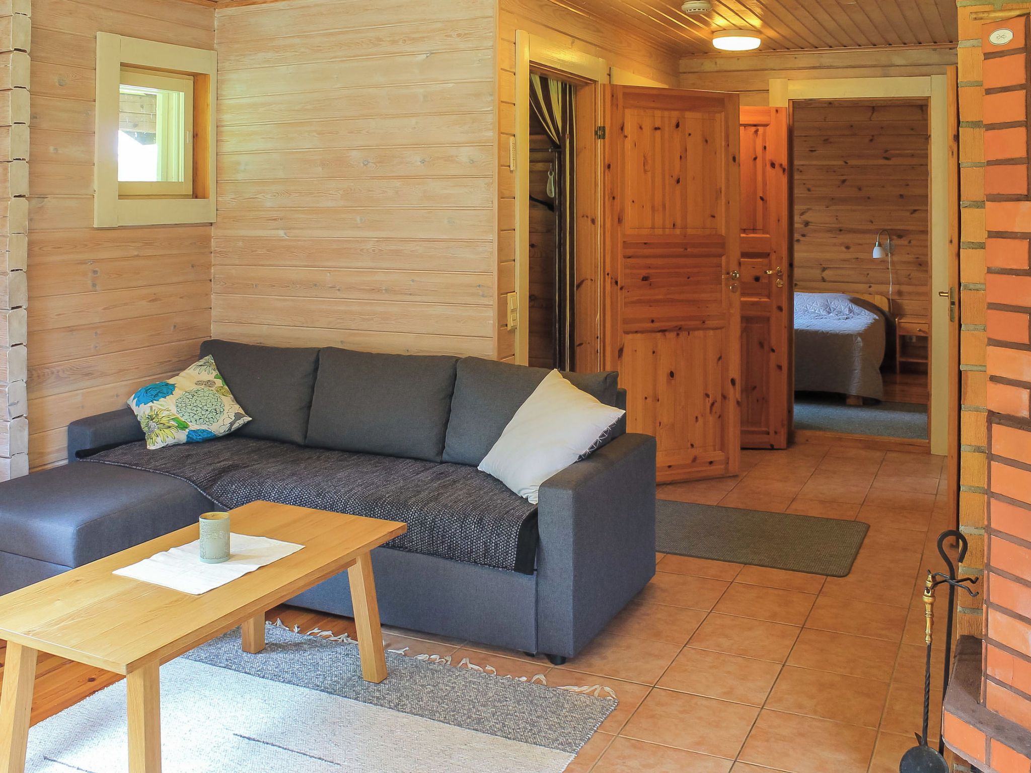 A cozy room with a sofa, a small table, and a wooden door leading to another room.