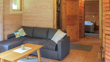 A cozy room with a sofa, a small table, and a wooden door leading to another room.