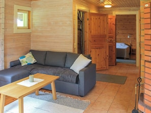 Una habitación acogedora con un sofá, una mesita y una puerta de madera que da a otra habitación.