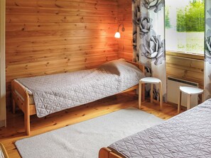 A small, cozy room with wooden walls and a single bed.