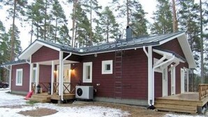 A cabin with a covered porch, a ladder, and a small outdoor area with a fire pit. - Ylä-hannala by Interhome (Muurame)