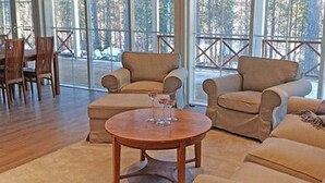 A spacious living room with large windows, a wooden coffee table, and beige sofas. - Ylä-hannala by Interhome (Muurame)