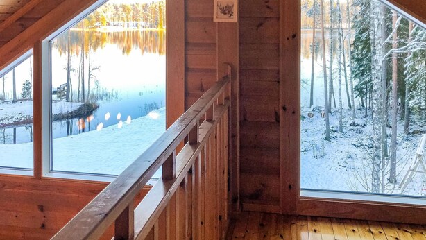 A cabin with large windows offering views of a snowy landscape and a lake. - Vacation home Inkeri by Interhome (Jämsä)
