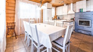 A wooden interior with a dining area, kitchen, and a fireplace. - Vacation home Inkeri by Interhome (Jämsä)